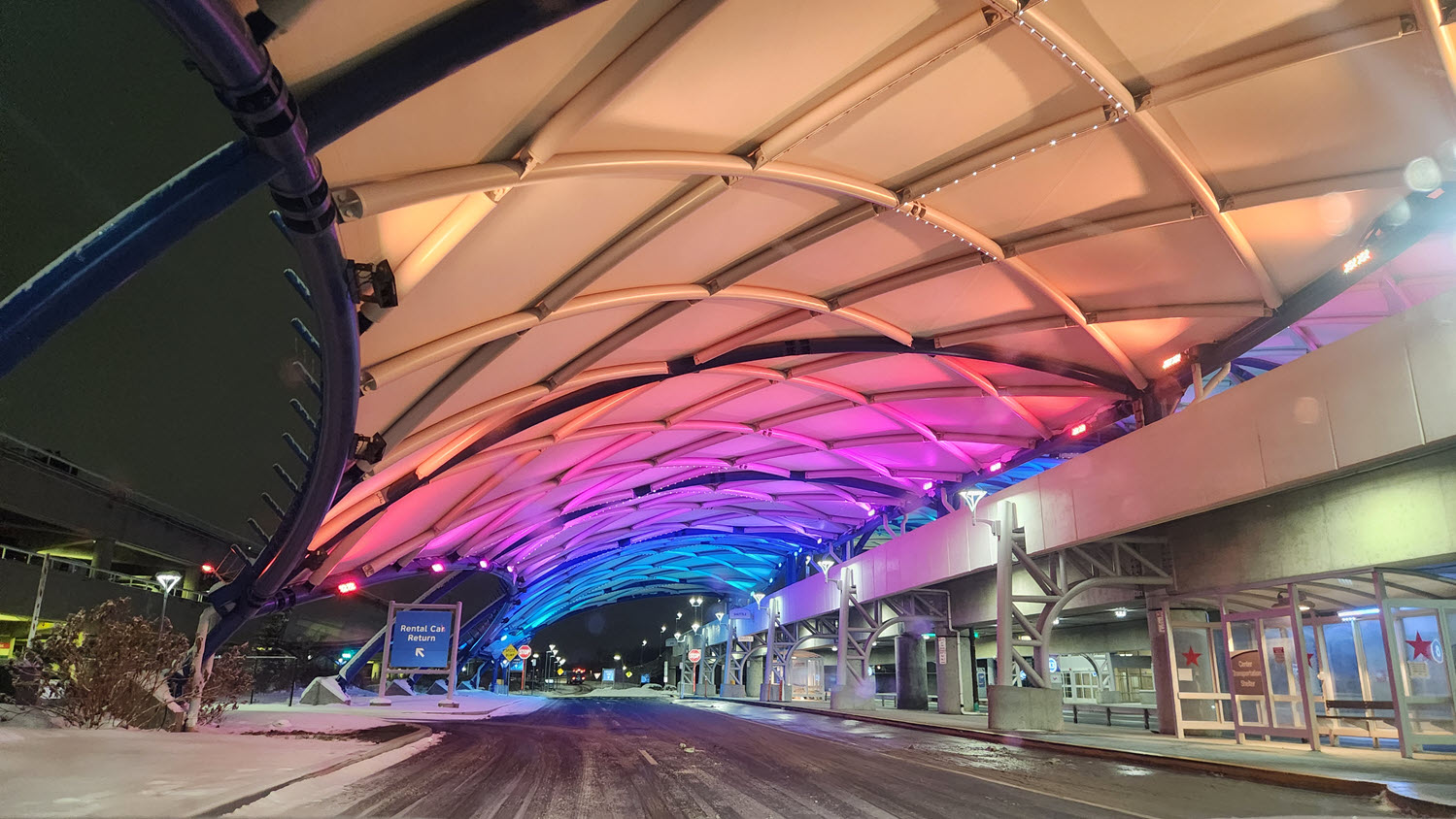 Rochester, NY, airport drop-off area with colorful lights showing on the underside of the roof