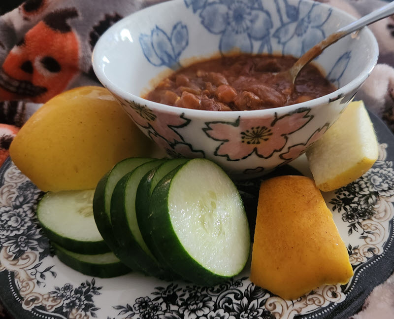 Bowl of chili with apples and cucumbers